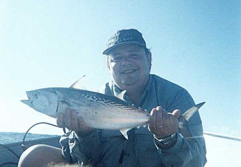 1979 Ford Bronco - A man proudly displays a freshly caught fish while out on the water.