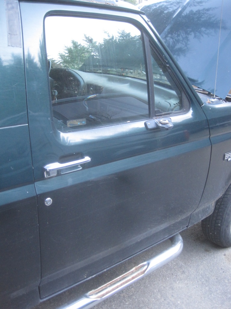 Green 1993 Ford Bronco side door with chrome handle and running board, hood open