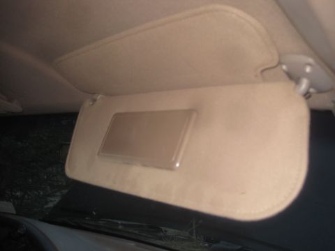 1993 Ford Bronco - The interior of a vehicle shows a tan sun visor with a vanity mirror, viewed from below.