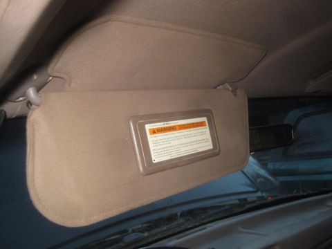 1993 Ford Bronco - Sun visor with an airbag warning label inside a vehicle.