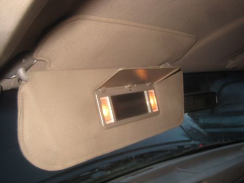 1993 Ford Bronco - The illuminated vanity mirror in the vehicle's sun visor is open.