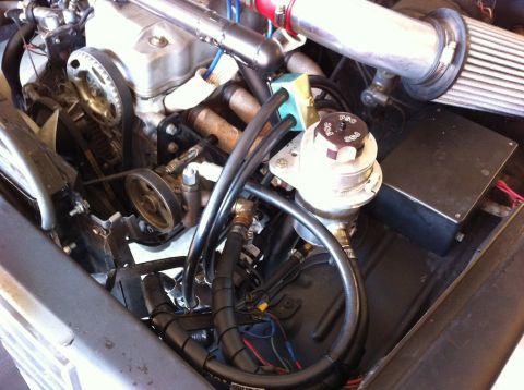 1987 Suzuki Samurai - Close-up view of engine components, including a turbocharger and associated plumbing.