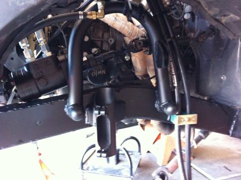 1987 Suzuki Samurai - Close-up view of the front axle and linked suspension system, showing hydraulic lines and steering components.