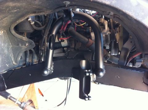 1987 Suzuki Samurai - Close-up view of the front axle and suspension system, with engine components in the background.