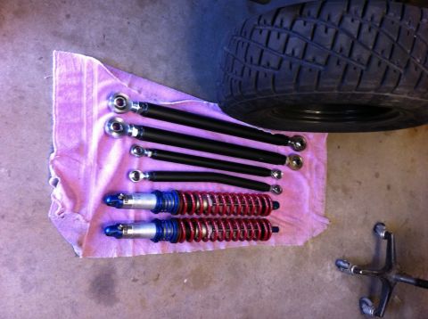 1987 Suzuki Samurai - Suspension components and a tire are displayed on a towel, suggesting a vehicle repair or upgrade.