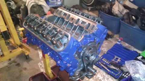 1973 Ford Torino - A blue V8 engine, likely undergoing a rebuild, is shown on an engine stand with tools nearby.