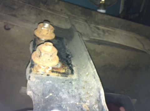 1992 Ford F-150 - Detail shot of corroded bolts and mounting bracket on a vehicle's undercarriage.