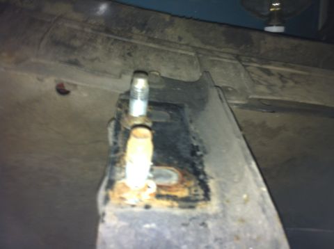 1992 Ford F-150 - Close-up of a rusted metal bracket with a bolt and nut, likely from a vehicle's undercarriage.