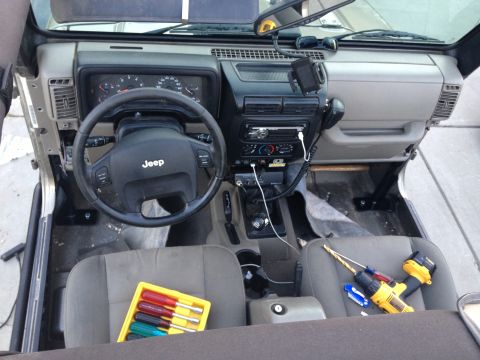 2005 Jeep Wrangler - The interior of a Jeep is shown with tools laid out on the seats, suggesting ongoing work or maintenance.