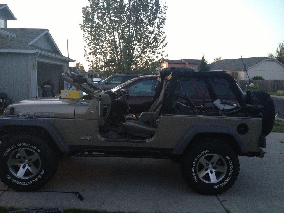 2005 Jeep Wrangler side view, soft top removed, parked in driveway