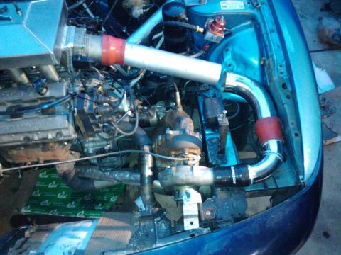 1995 Ford Probe - Custom turbocharger setup in an engine bay with aftermarket piping.