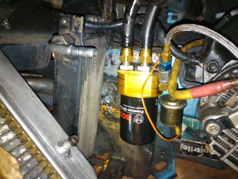 1995 Ford Probe - Close-up of an engine bay showing an aftermarket oil filter and cooler lines, with visible text from Supermotors.net.