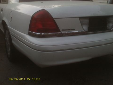 2006 Ford Crown Victoria - White 2006 Ford Crown Victoria rear view, showing taillight and chrome trim detail.