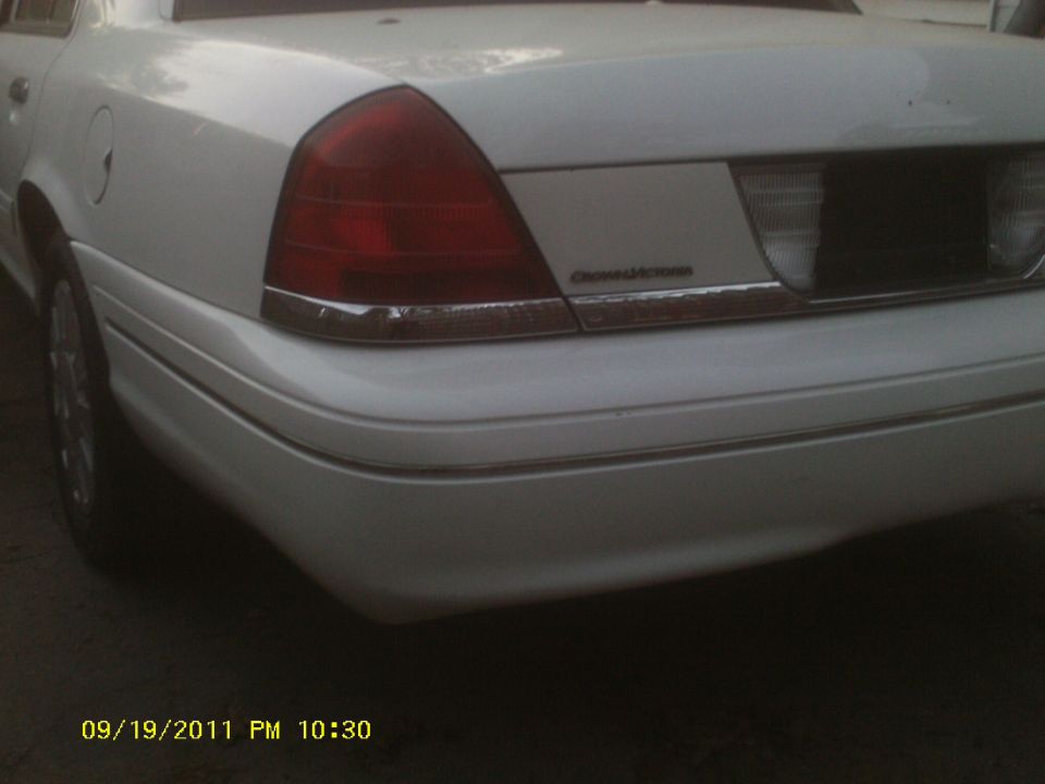 Rear quarter view of a white 2006 Ford Crown Victoria showing the taillight and trunk lid trim