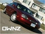 1998 Mercury Sable - 1998 Mercury Sable coupe in dark red, seen from a 3/4 front angle on a residential street.