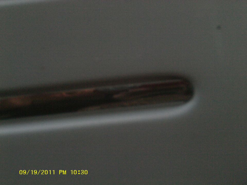 Close-up of a car door handle, with a timestamp 09/19/2011 PM 10:30 visible