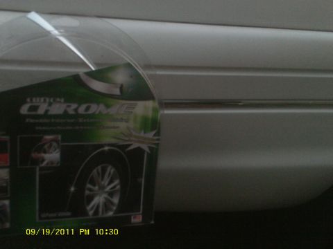 2006 Ford Crown Victoria - Packaging for custom chrome trim is placed in front of a white car's side panel.