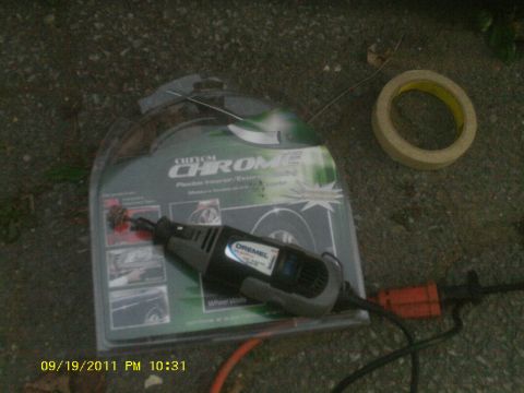 2006 Ford Crown Victoria - A Dremel rotary tool and a custom chrome trim kit are laid out on the ground next to a roll of tape.