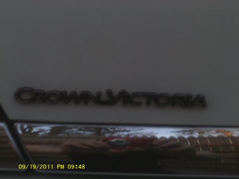 2006 Ford Crown Victoria - A close-up of the Crown Victoria badge on a car, with chrome trim visible below.