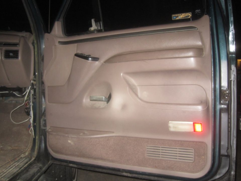 Interior door panel with armrest, window controls, and a red light