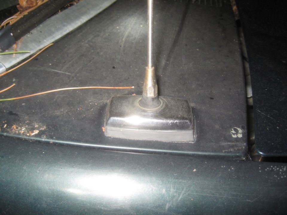 Antenna base on dark hood with visible Supermotors.net watermark