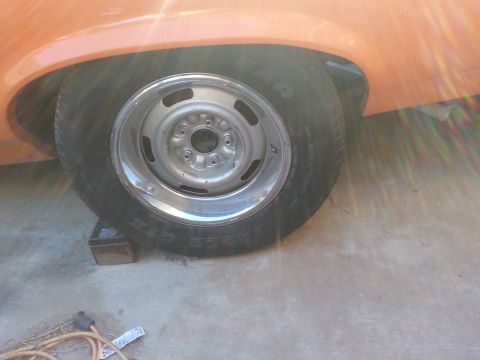 1973 Chevrolet Nova - Close-up of the rear wheel and fender of a 1973 Chevrolet Nova, painted orange.