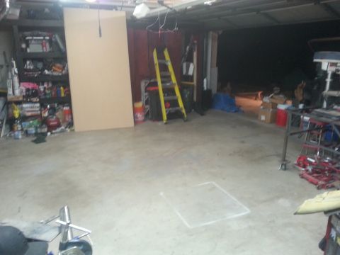 1973 Chevrolet Nova - A cluttered garage scene with storage shelves, a yellow ladder, and equipment visible.