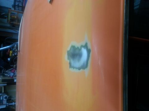 1973 Chevrolet Nova - A section of a car door shows a patch of body filler being prepared for paint.
