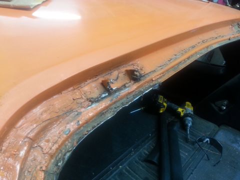1973 Chevrolet Nova - Rust damage on a car's body panel is being prepped for repair with tools present.