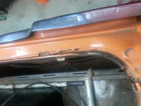 1973 Chevrolet Nova - Rust damage is visible on the orange car body panel near the chrome trim.