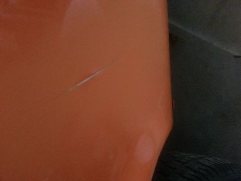 1973 Chevrolet Nova - A scratch is visible on the orange paint of a vehicle's body panel.