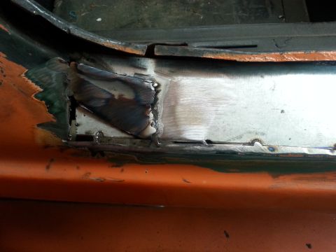 1973 Chevrolet Nova - Detail of metalwork and welding on an orange car, likely during a repair or restoration process.