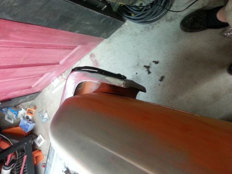 1973 Chevrolet Nova - Car bumper in primer, likely undergoing bodywork or painting in a workshop setting.