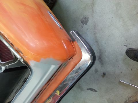 1973 Chevrolet Nova - The rear corner of a car is shown with primer and orange paint, indicating bodywork in progress.