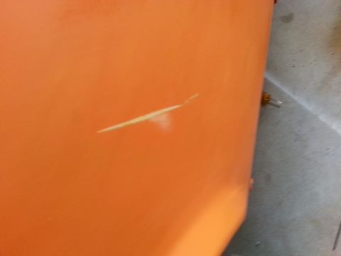 1973 Chevrolet Nova - A close-up of an orange painted surface shows a scratch.