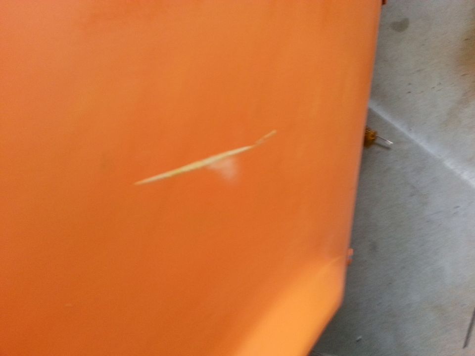 Orange painted surface with a scratch, close-up view