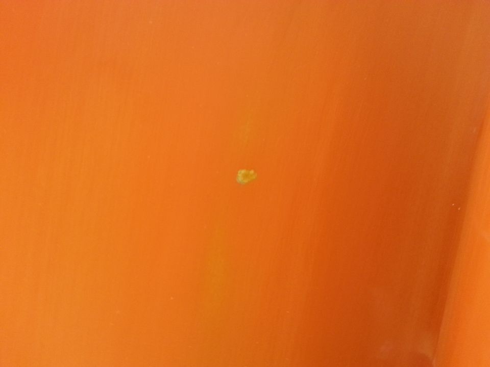 Orange paint blemish on a vehicle part