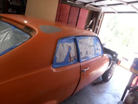 1973 Chevrolet Nova - Orange 1973 Chevrolet Nova coupe undergoing paint preparation in a garage.