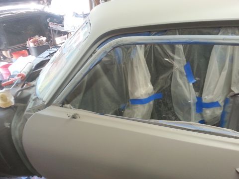 1973 Chevrolet Nova - The side of a 1973 Chevrolet Nova is prepped for painting, with the door and window frames covered in protective tape and plastic.