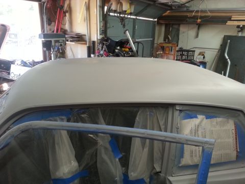 1973 Chevrolet Nova - A car is being prepped for paint in a garage, with the roof covered in primer and windows taped off.
