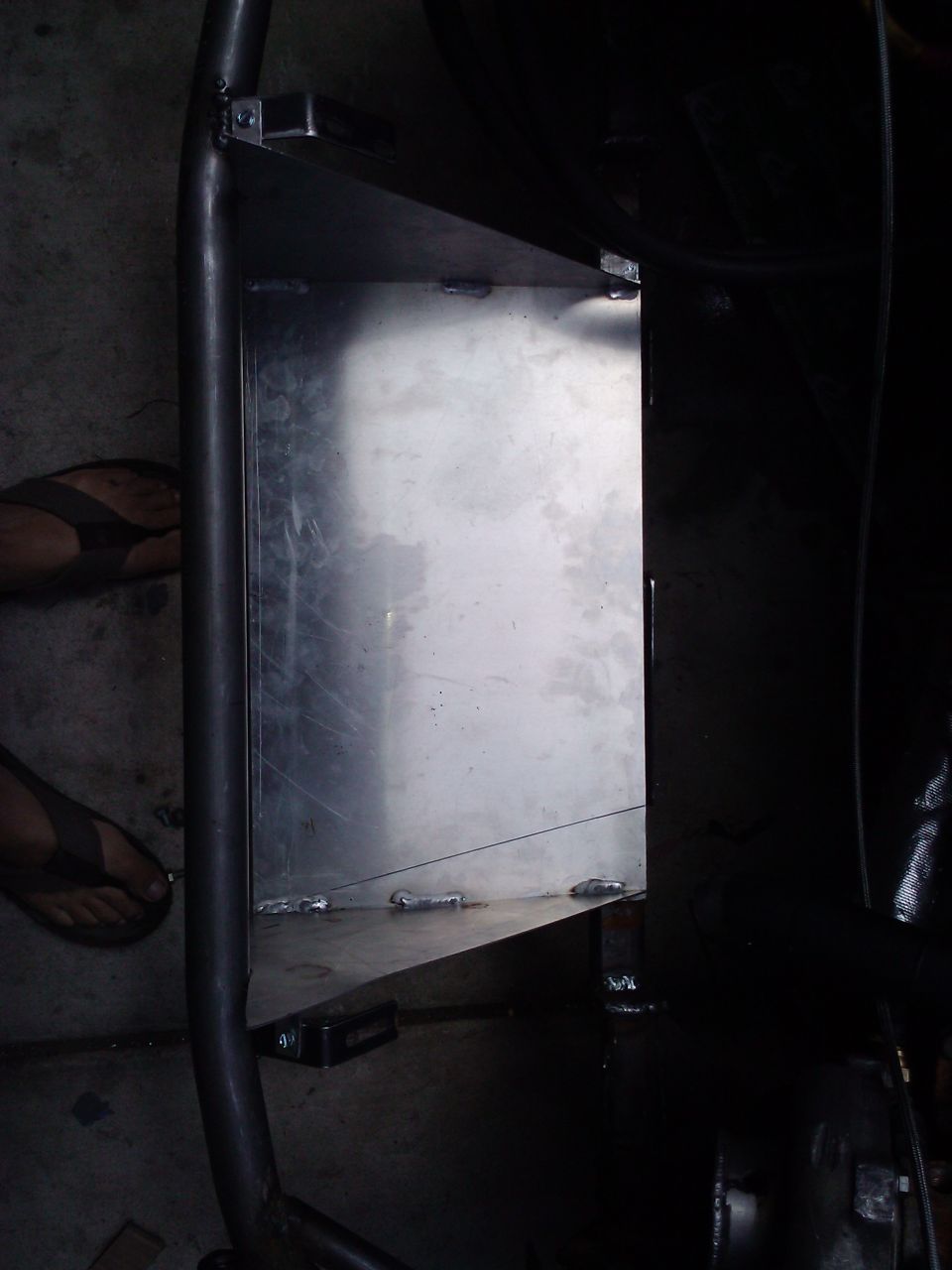 Custom metal box with welded seams and a curved pipe frame
