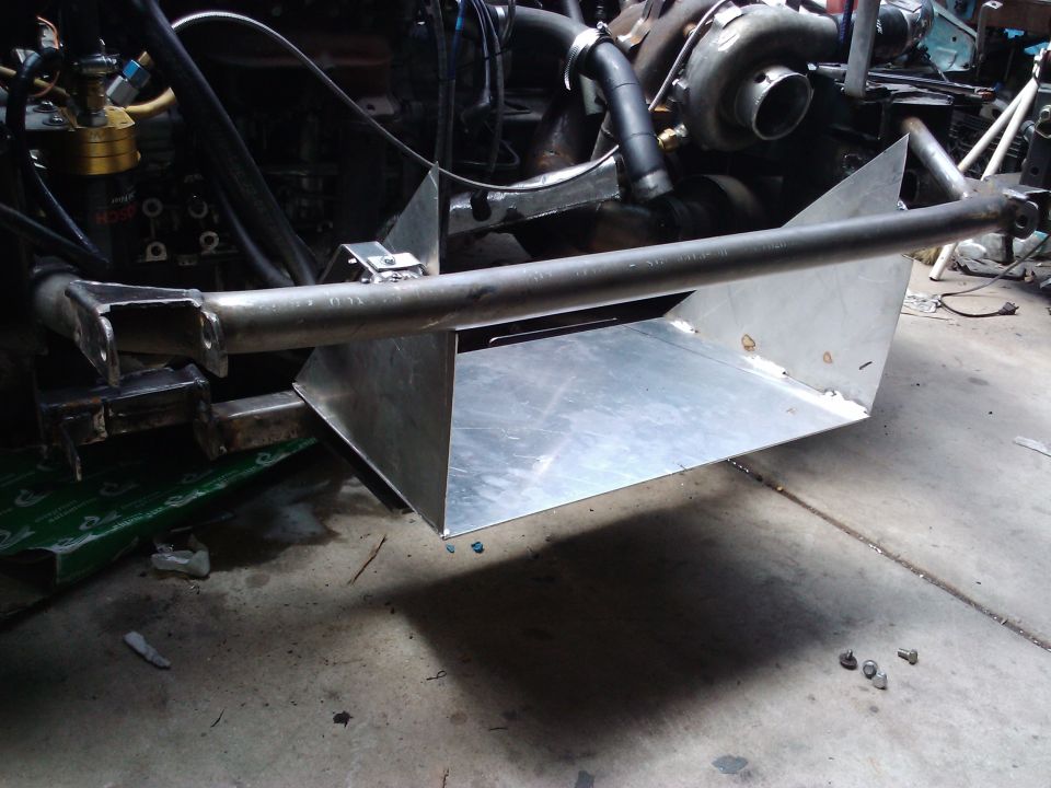 Custom aluminum air dam and support bar installed on vehicle frame, with engine components visible behind