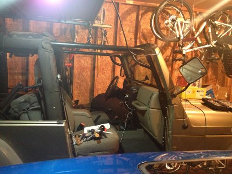 2005 Jeep Wrangler - Interior view of a 2005 Jeep Wrangler, showing the seats and roll cage, with garage items in the background.