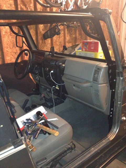 2005 Jeep Wrangler - The interior of a Jeep Wrangler is visible, an aftermarket roll cage and the dashboard area.