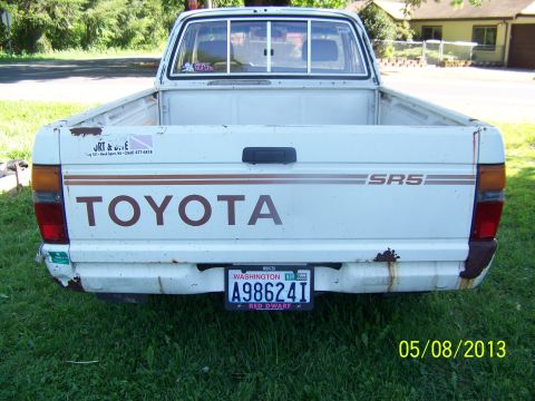 1988 Suzuki Samurai - This white Toyota pickup truck is seen from the rear, showing its tailgate and license plate.