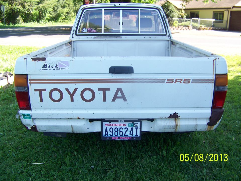 White Toyota pickup truck, rear view, with SRS badging and Washington license plate A98624I