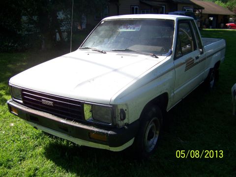 1988 Suzuki Samurai - This 1988 Toyota pickup truck is parked on a grassy area in front of a house. A 'For Sale' sign is visible in the windshield.