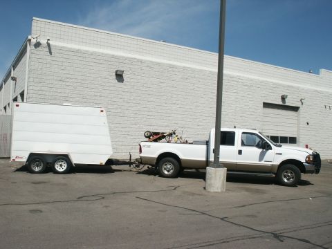 2000 Ford F-250 - Side view of a 2000 Ford F-250 Super Duty pickup truck towing a white cargo trailer.