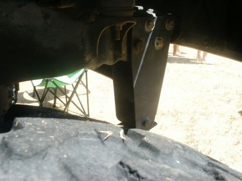 2000 Ford F-250 - A low-angle view focuses on the undercarriage of a vehicle, showing suspension components and a large tire.