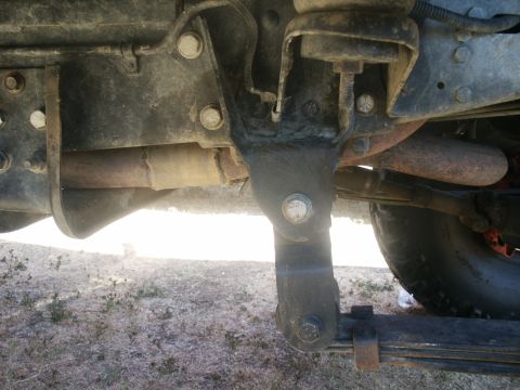 2000 Ford F-250 - Close-up view of the undercarriage of a truck, showing suspension components and exhaust system. The Supermotors.net logo is present in the…